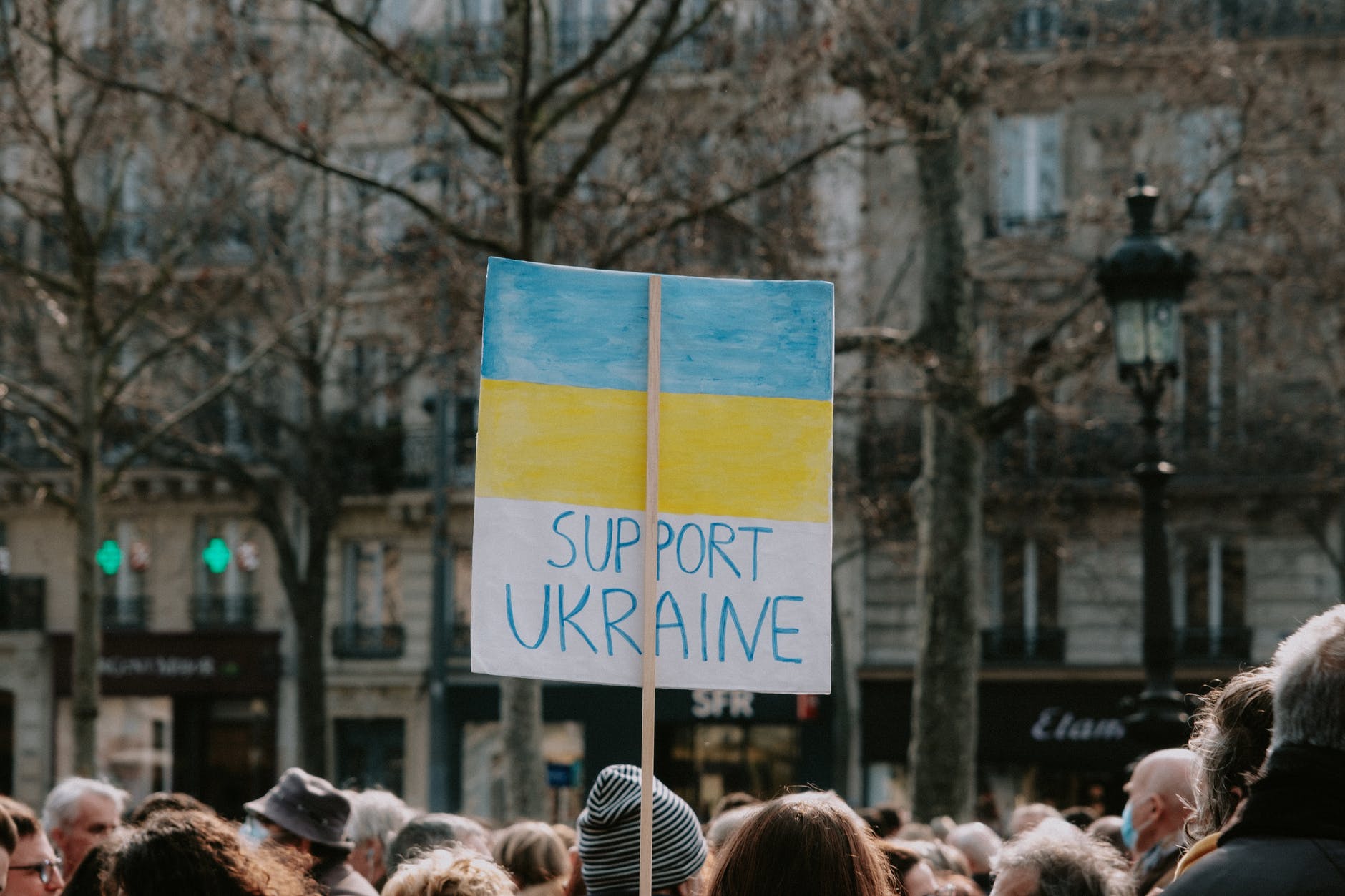 large group of people holding banner on supporting ukraine