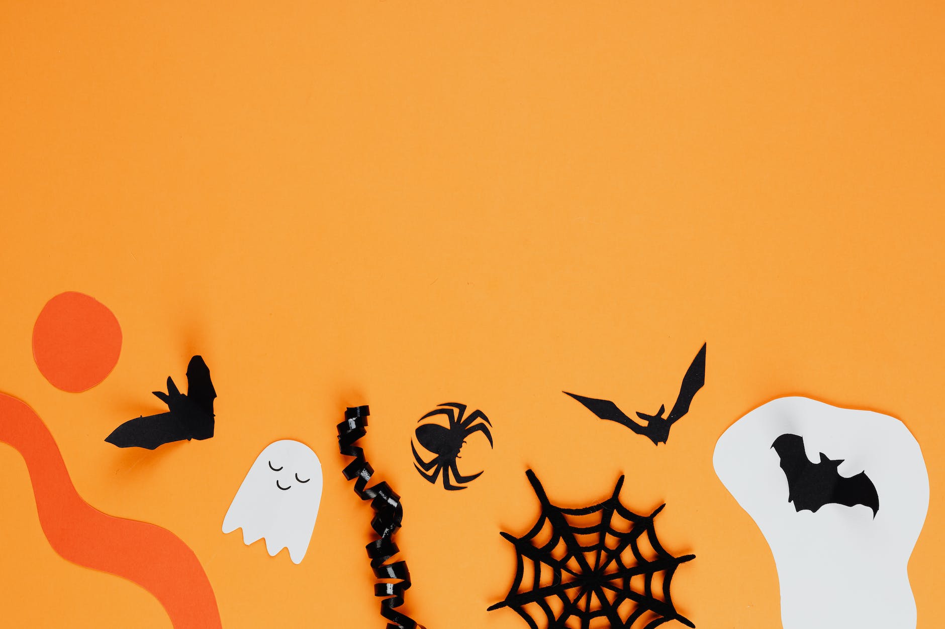 paper halloween decorations on an orange background