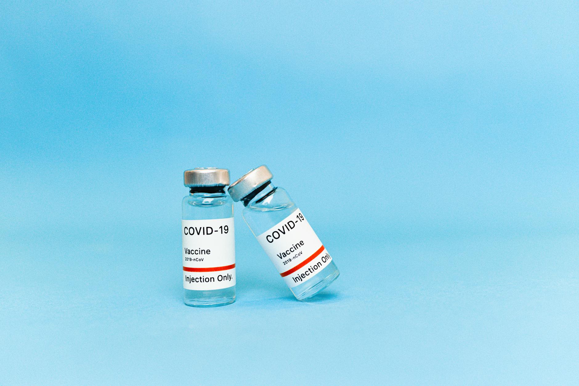 covid vaccine bottles on blue surface