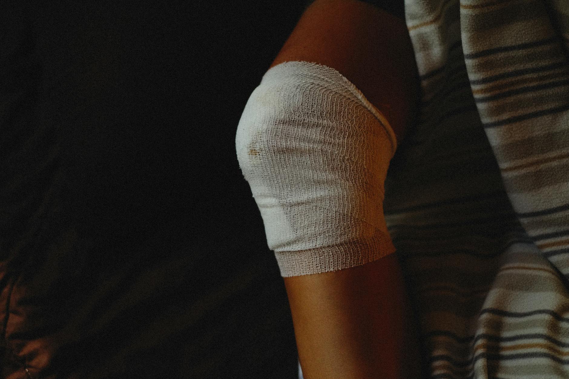 person with medical gauze bandage on injured knee