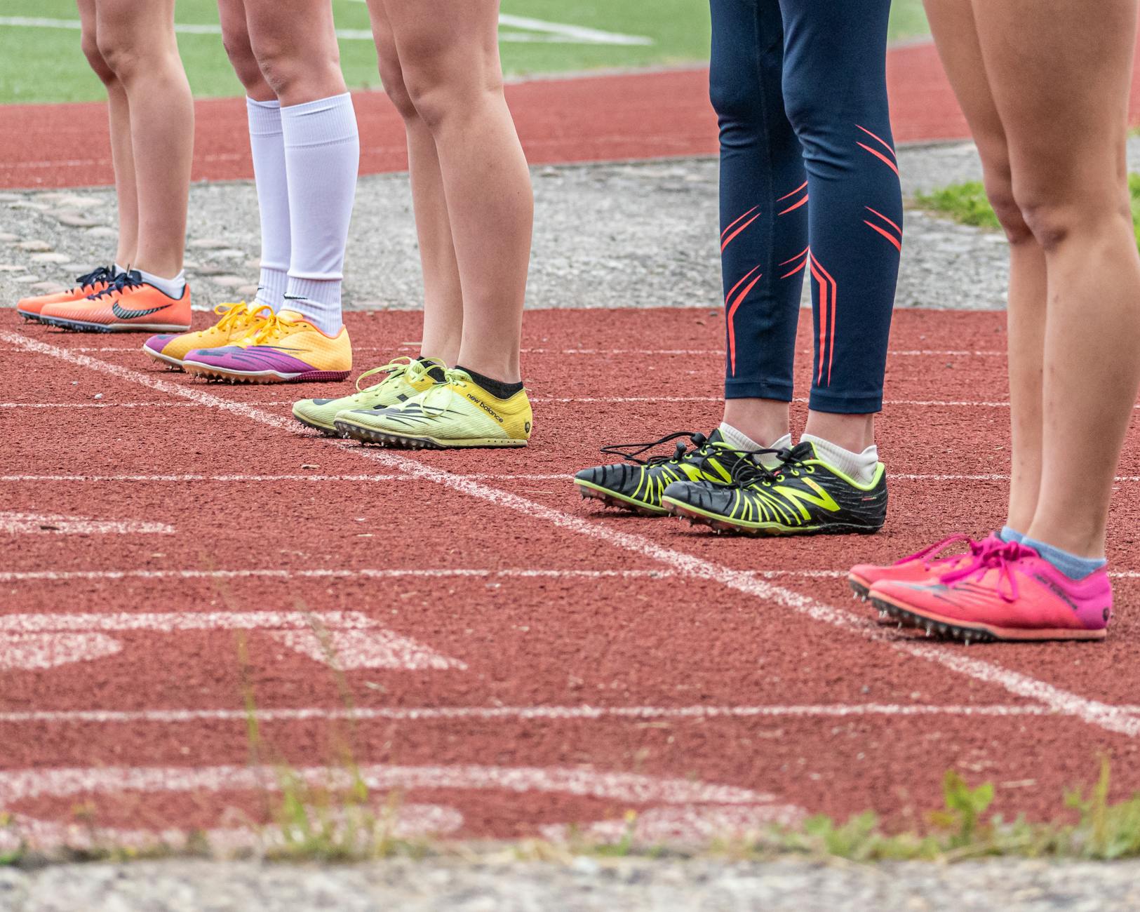 people wearing running shoes standing on the track