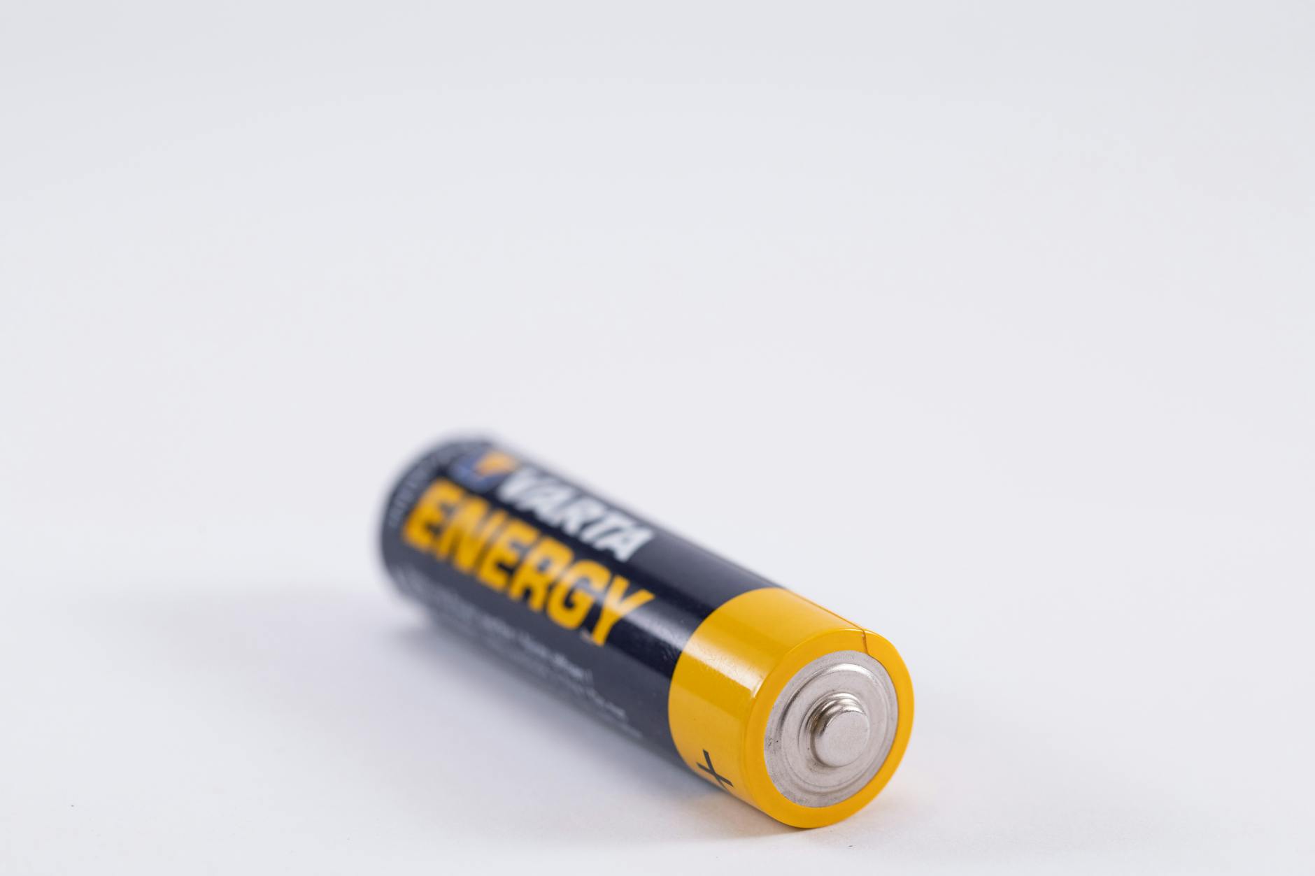 black and yellow battery on white surface