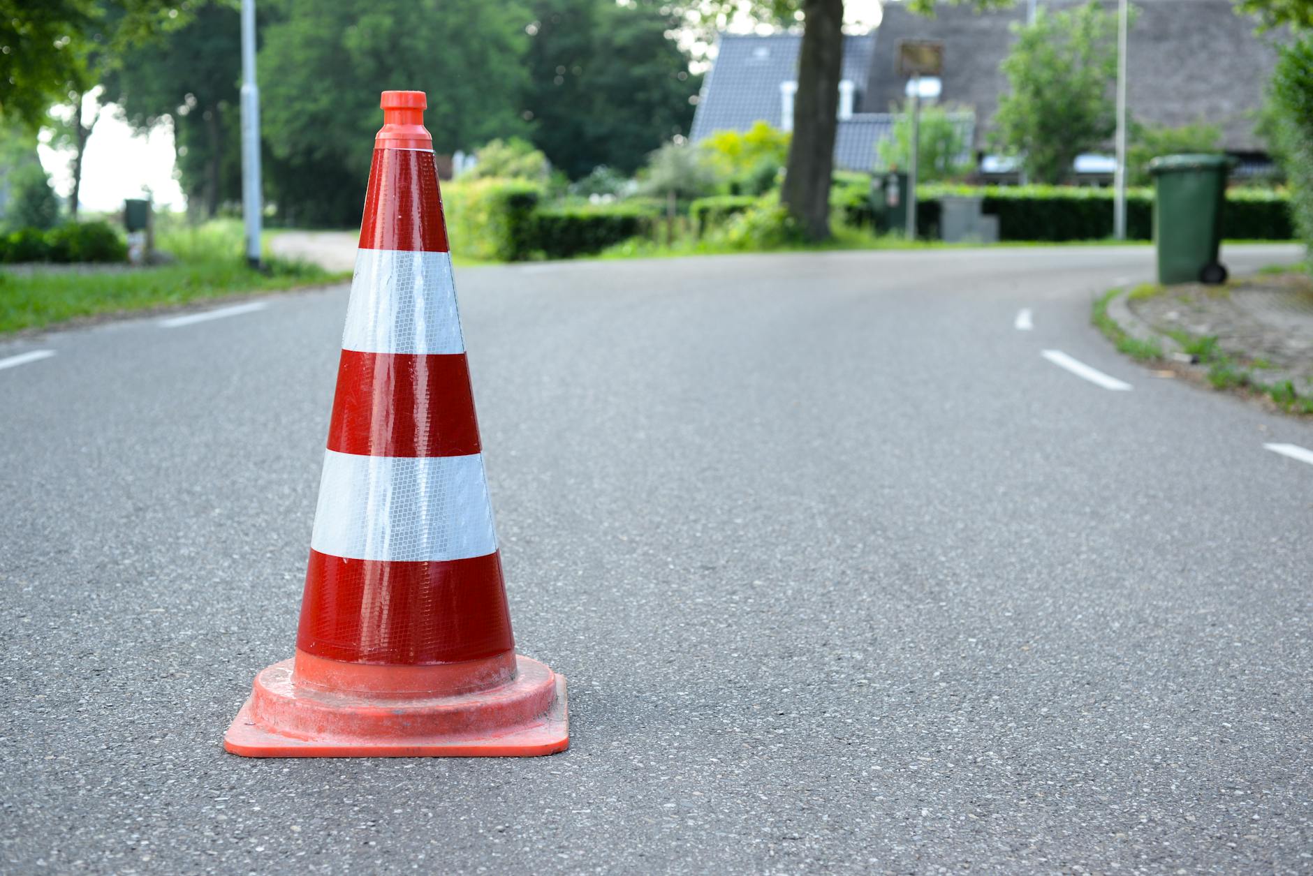 red and white traffic cone on road