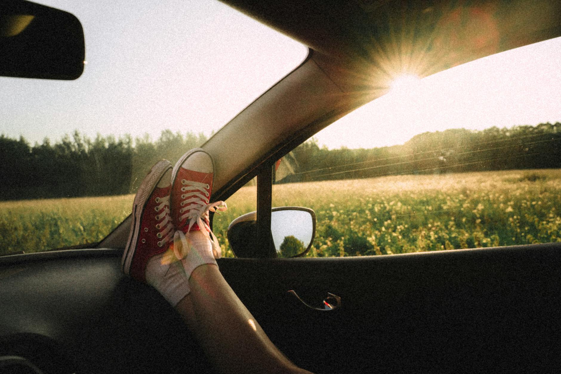 person in a vehicle with legs stretched on the dashboard